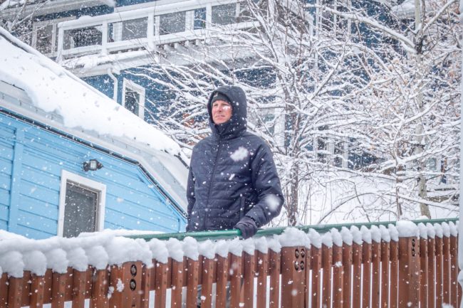 Guy walking down stairs while it's snowing.