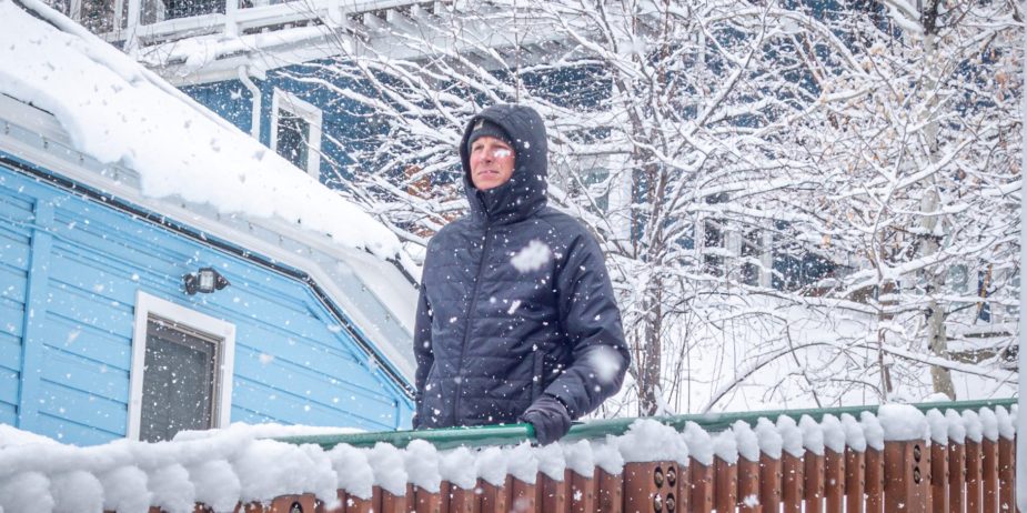 Guy walking down stairs while it's snowing.